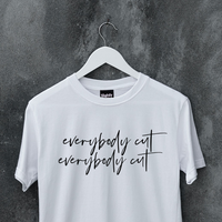 White slogan tee on a hanger. Slogan says everybody cut as a reference to the 80s movie footloos